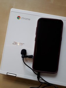 A Chromebook with a smart phone and microphone